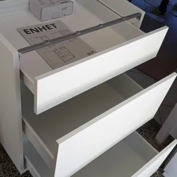 Smontirani bijeli enhet element sa otvorenim ladicama  bočno slikan