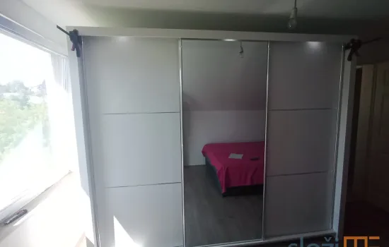 Složen siena ormar bijele boje sa kliznim vratima slikan sprijeda